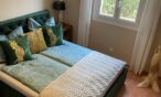 Schlafzimmer Smaragd mit Chesterfield Bett und Kleiderständer Teak