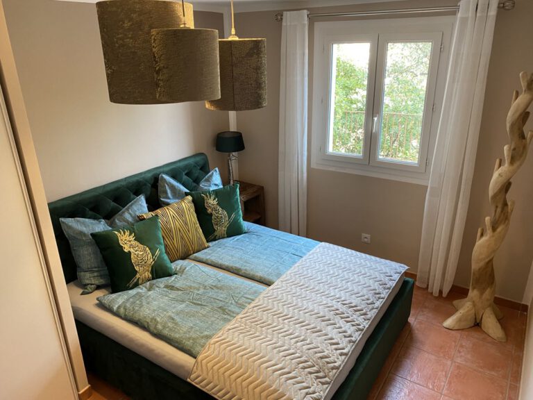 Schlafzimmer Smaragd mit Chesterfield Bett und Kleiderständer Teak