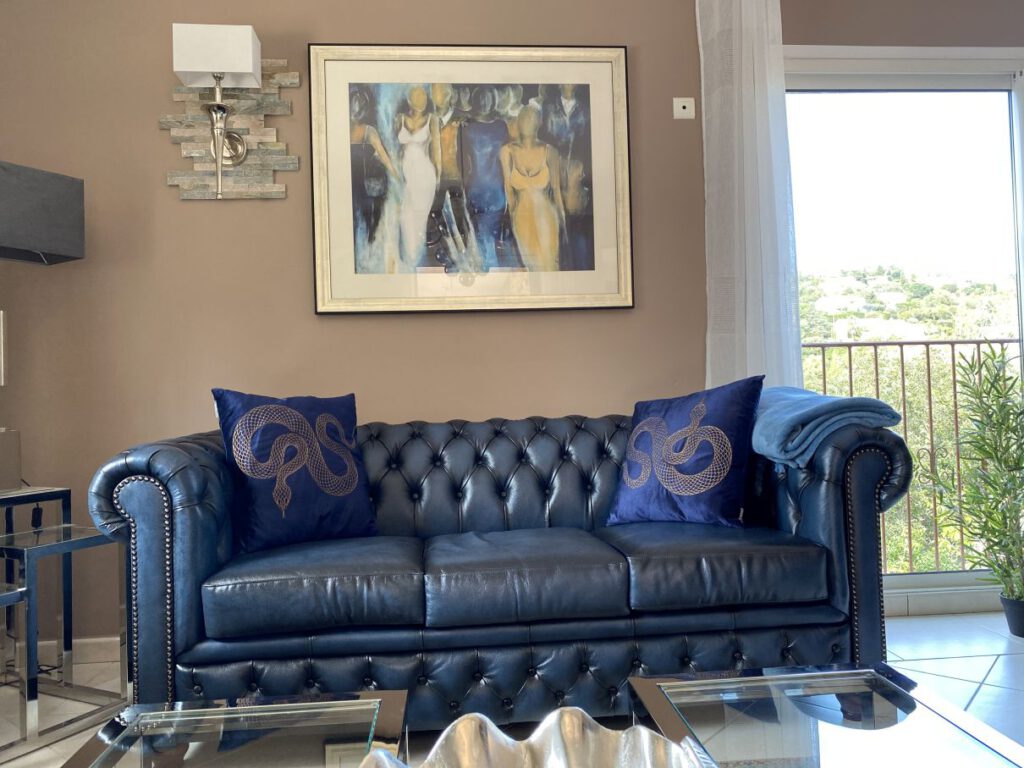 Chesterfield 3-Sitzer dunkelblau mit blauen Kissen Glastisch mit silberner Muschel