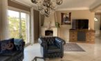 Chesterfield Sessel dunkelblau mit Kamin im Hintergrund und Fernseher auf Teakholz Sideboard