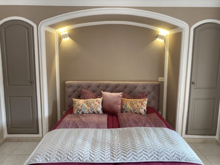 Schlafzimmer rosa mit Chesterfield Bett und Schränken